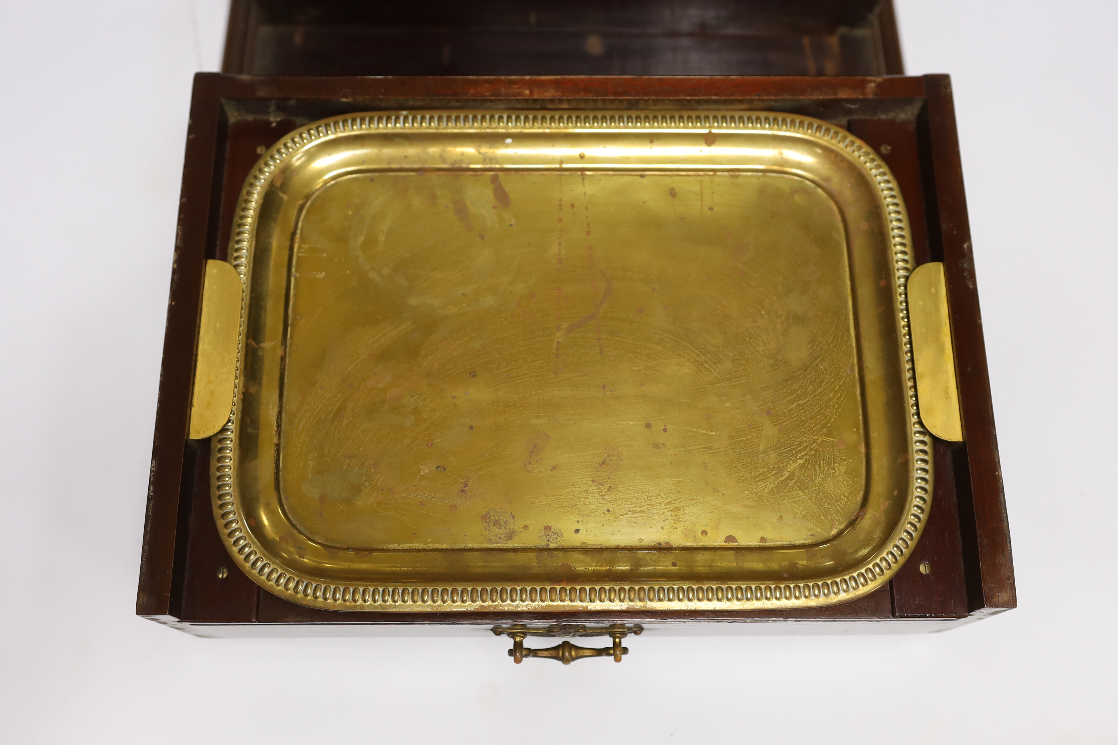An Edwardian Sheraton revival inlaid mahogany portable drinks cabinet with tantalus and other accessories including serving trays, a brass cribbage board, with secret drawer, etc, 37cm high